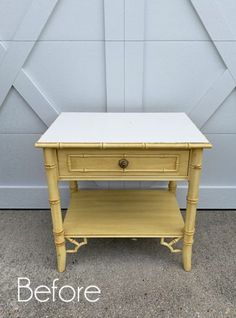 a yellow end table sitting in front of a garage door with the words before painted on it