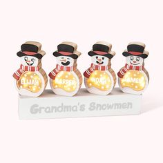 three snowmen with hats and scarfs are standing in front of a sign that says grandma's snowmen