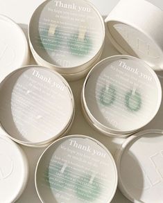 six personalized dishes with thank you written on the lids in white paper and green ink