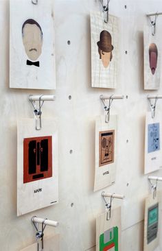 a wall with many pictures hanging on it's sides and hooks attached to the walls