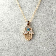 Introducing our newest product - our Hamsa Evil Eye Protector Necklace.  This beautiful necklace incorporates gorgeous diamond effect crystals and a beautiful blue topaz stone.  The necklace is 50cm long with a 5cm adjustable chain.  This piece is gold plated, and it looks just as stunning in person.  The perfect present for your loved one or spoil yourself and be the envy of your friends & family x  This piece also comes in a black gift box. Evil Eye Hand, Blue Crystal Necklace, Gold Hamsa, Hamsa Pendant, Hamsa Necklace, Outfit Yoga, Hand Necklace, Crystal Fashion, Color Jewelry