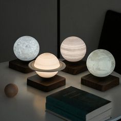 three different types of lights sitting on top of a table next to a book and lamp