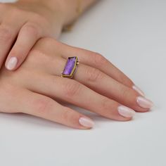 A vibrant faceted amethyst is wrapped in warm 22k gold, accented with three sparkling diamonds. The stone measures approximately 3/8 inch x 3/4 inch. Sterling silver back and 2mm hammered band. Matte finish.