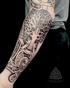 a man's arm with an intricate tattoo design on the left side of his arm