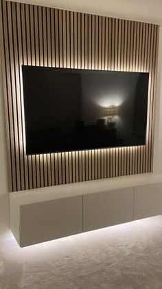 a large television mounted to the wall in a living room with lights on it's sides