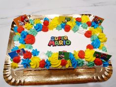 there is a cake that says super mario on the top and colorful decorations around it