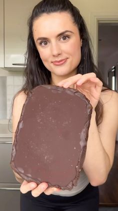 a woman holding up a piece of chocolate