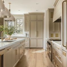 a large kitchen with white cabinets and wood flooring, along with stainless steel appliances