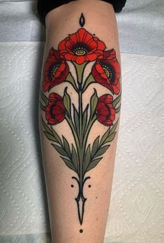 a woman's leg with red flowers and leaves on the side of her body