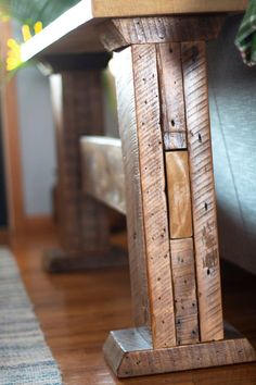 a wooden bench sitting on top of a hard wood floor next to a planter