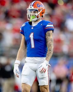 a close up of a football player wearing a helmet and holding a ball in his hand