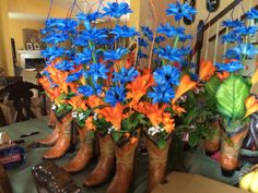 there are many boots with blue flowers in them on the table next to each other