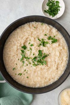 a bowl filled with rice and parsley on top of a table