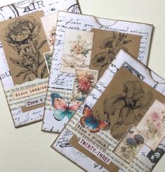 several old fashioned postcards with flowers and butterflies on them are stacked up in a pile