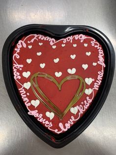 a heart shaped cake with white and pink frosting