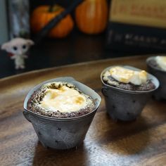 three cupcakes sitting on top of a wooden table