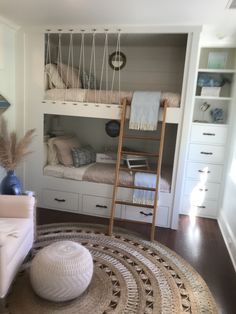 a bunk bed in a room with white furniture and rugs on top of the floor