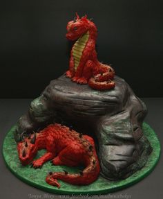 a red dragon statue sitting on top of a green plate next to a black background