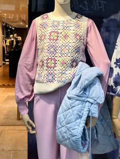 the mannequin is dressed in pastel clothing and has a blue jacket on it