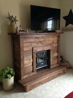 a flat screen tv sitting on top of a wooden fireplace