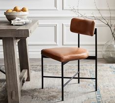 a brown leather chair sitting in front of a table with fruit on top of it