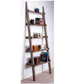 a ladder shelf with books and other items on it next to a wall in a room