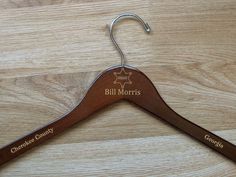 a wooden coat hanger with the name bill morris on it