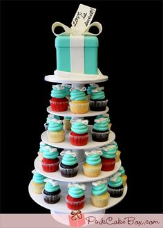 a tiered cake with cupcakes on it