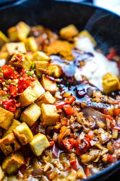 the food is being cooked in the skillet on the stove with some sauce and seasoning