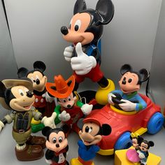 many mickey mouse figurines are posed together