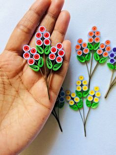 two handmade flowers are being held in front of each other