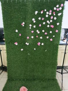 artificial grass with pink and white flowers arranged on it