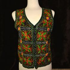 This vest is an embroidered vest with floral pattern and small mirrors woven into it. It reminds me of an El Matador vest Would work great for an ugly Christmas sweater party or for a Halloween costume, Mardi Gras or just getting back to your roots! DETAILS Condition: Good MEASUREMENTS Size on tag: Women's Large could work for men also Back of neck to Bottom: 19.5" Armpit to Armpit: 18.5" All measurements are taken flat across garment. For most accurate size please double check measurements against one of your own garments. Vintage sizes vary from modern sizes.  I am happy to provide any other measurements you need - just ask!! This item is pre-worn but is in good condition.  Any piling or imperfections are part of the charm and character of the item and should be taken into consideration Multicolor Vest Tank Top For Festival, Embroidered Sleeveless Vest For Fall, Sleeveless Embroidered Vest For Fall, Embroidered Multicolor Spring Vest, Multicolor Embroidered Vest For Spring, Spring Embroidered Multicolor Vest, Spring Multicolor Embroidered Vest, Festive Embroidered Sleeveless Vest, Embroidered Multicolor Vest For Festivals