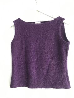 a purple top hanging on a white wall