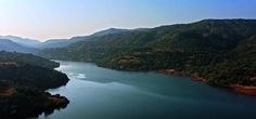 an aerial view of a lake surrounded by mountains