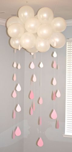 some white and pink balloons hanging from the ceiling