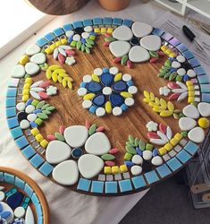 a wooden table topped with lots of different colored glass and tile pieces on top of it