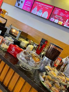 there are many food items on the counter at this restaurant, including muffins and pastries