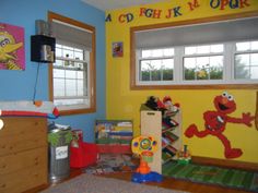 a child's bedroom with sesame the cat theme on the wall and other toys