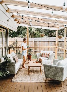 a woman is standing on the back porch