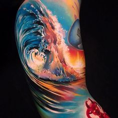 a man's arm with a colorful wave and red crab tattoo on his left side