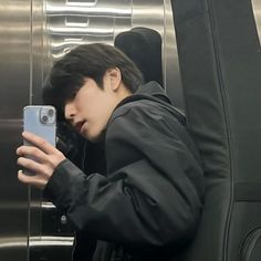 a man taking a selfie with his cell phone while riding an escalator