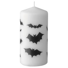 a white candle with black bats on it