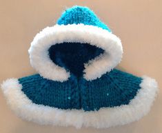 a blue and white knitted hat sitting on top of a table