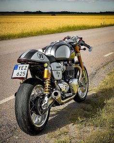 the motorcycle is parked on the side of the road in front of an empty field