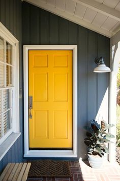 a yellow door is on the side of a house