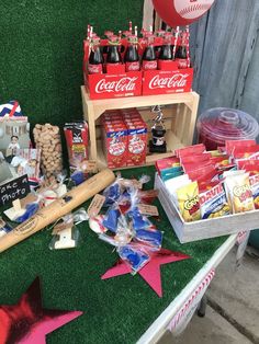 a baseball themed party with snacks and drinks on the grass next to a wooden table