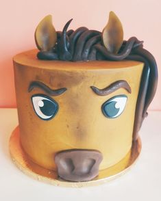 a cake decorated to look like a bear's head with horns and eyes on it