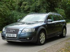 an audi car is parked on the side of the road in front of some trees