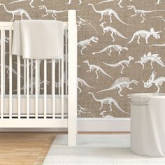 a baby's room with pink wallpaper and white crib in front of it